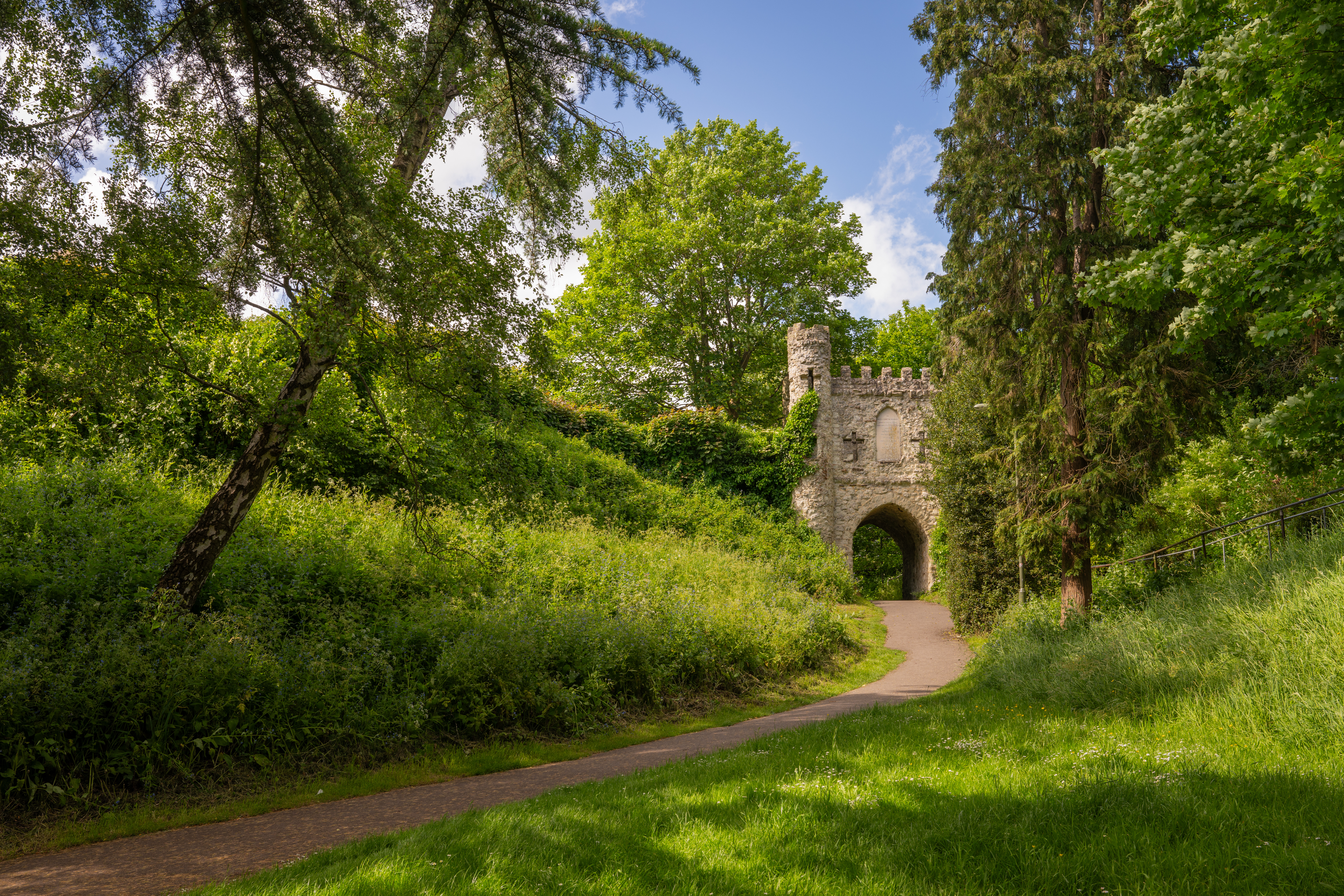 Winding path leading to the historic stone archway in Reigate